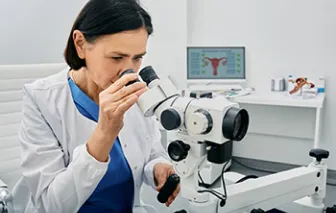 doctor looking through microscope on colopscopy