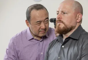 Dr. Han with patient performing an ear exam.