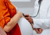 Woman in orange shirt is in doctor's office