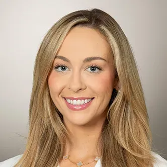 Ms. Simokaitis has long blond hair, is wearing a white medic