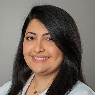 Dr. Al Allawi has long dark straight hair, is wearing a neck