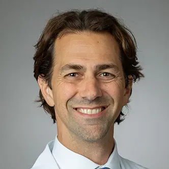 Dr. DiSandro has short brown hair and is wearing a white shi