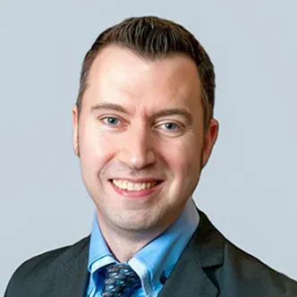 Dr. Smith has short dark hair, is wearing a blue shirt and w