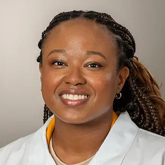 Ashley Walker has long, dark braids pulled back from her fac